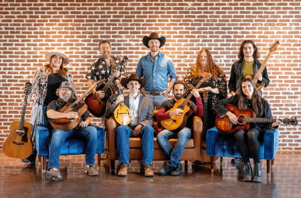 Group of Melody of Hope artists and musicians on a couch posing in front of a brick wall