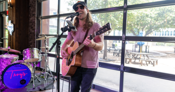 Local artist performing live at Troy's in Texas Live! during a summer community music event in partnership with Tango Charities.