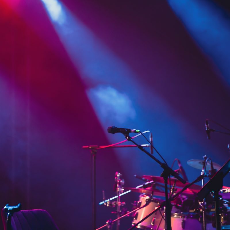Microphone in colored spotlights and smoke. Concert and theatre scene