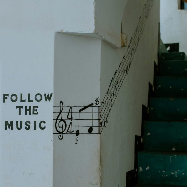 Staircase corridor with the message follow the music and music notes leading up staircase on the wall