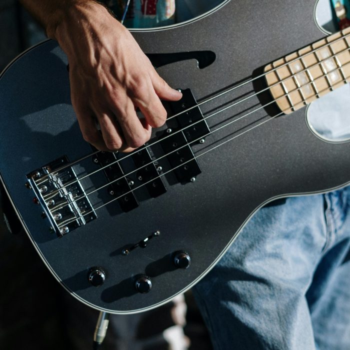Close up of musician playing the base guitar
